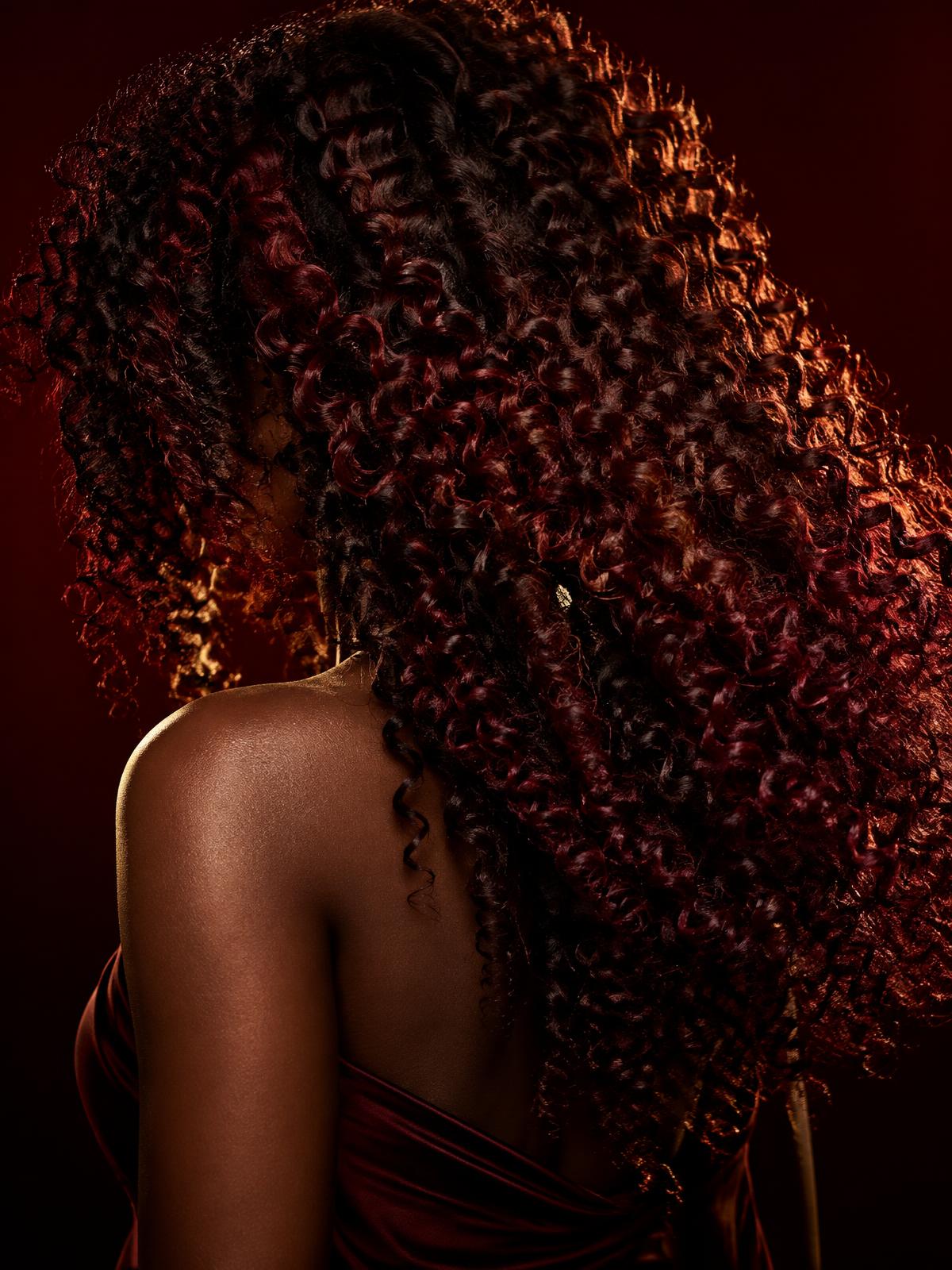 Faceless editorial portrait highlighting coils hair texture